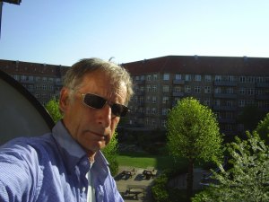 Erik Kristian Abrahamsen. Født 1945 i Skagen. Boet i København siden 1983. Her på min altan på Nørrebro med udsigt til vor grønne gård med udsprungne kirsebærtræer.